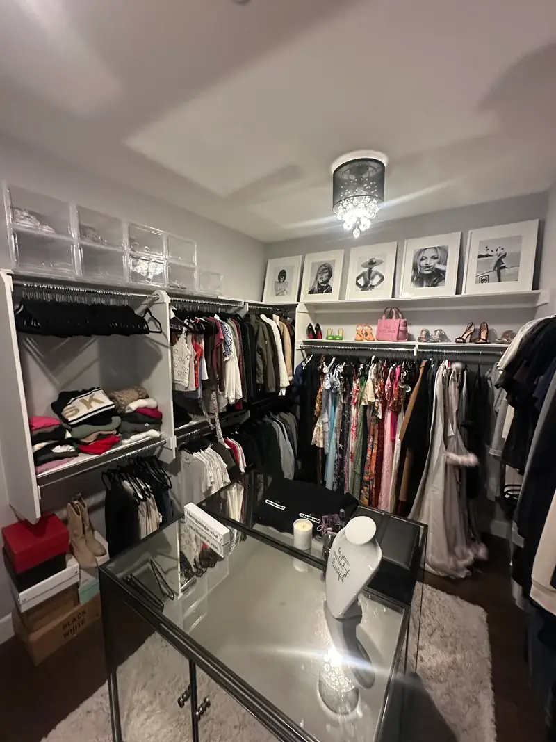 Before: Huntington Beach walk-in closet with crowded rods and a glass island in the middle of the room