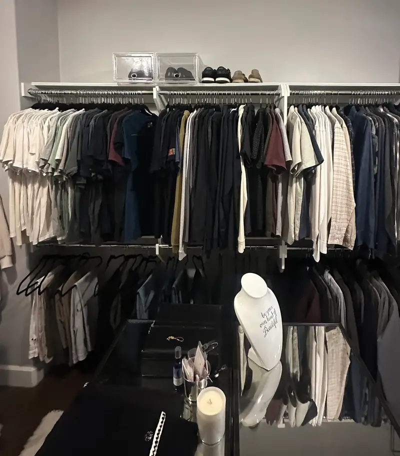 Before: men's side of a Huntington Beach walk-in closet with crowded shirts and a cluttered glass island