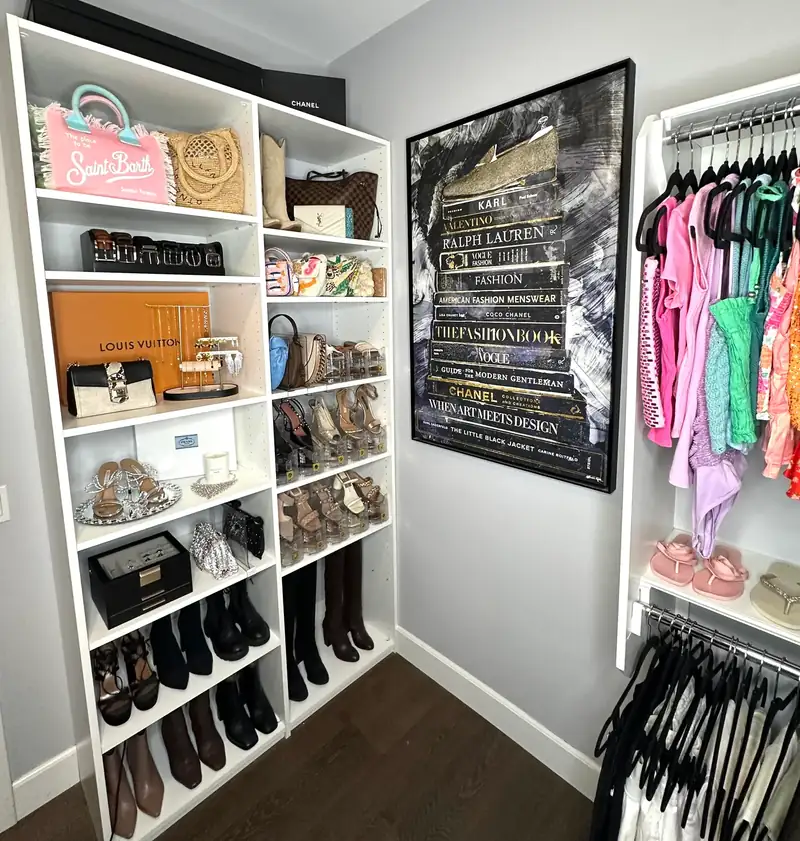 After: Huntington Beach walk-in closet shelves with handbags and shoes in neat rows next to framed fashion art