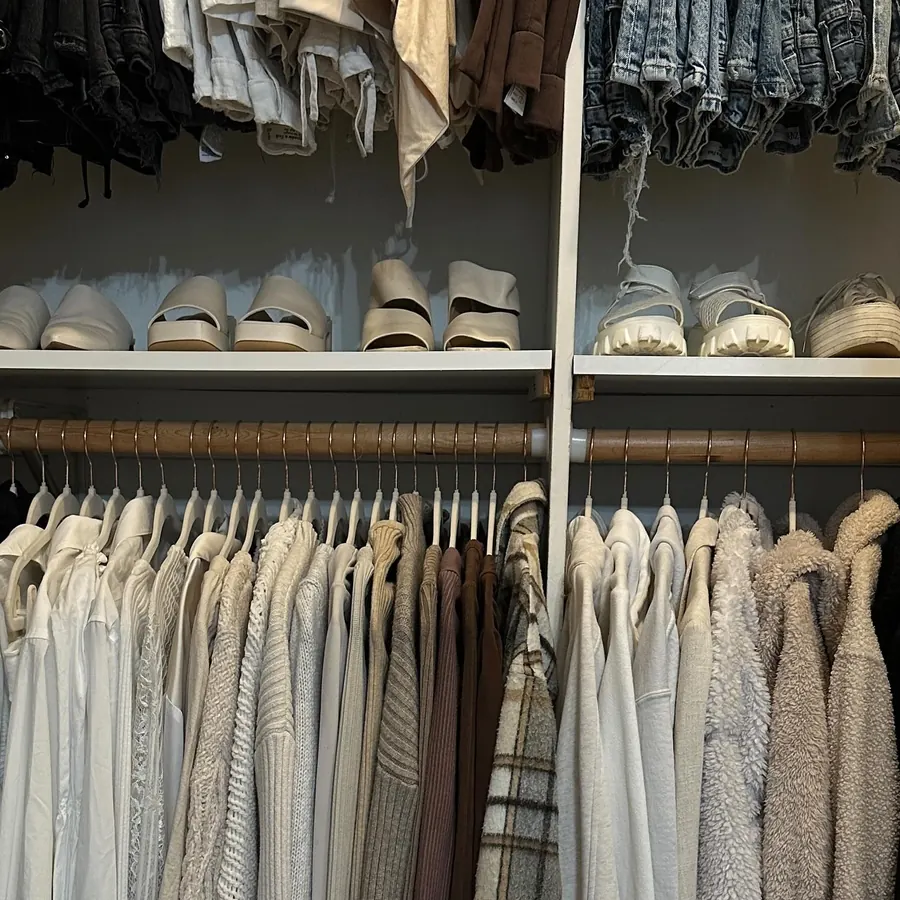 Neutral sweaters and tops hanging in neat rows