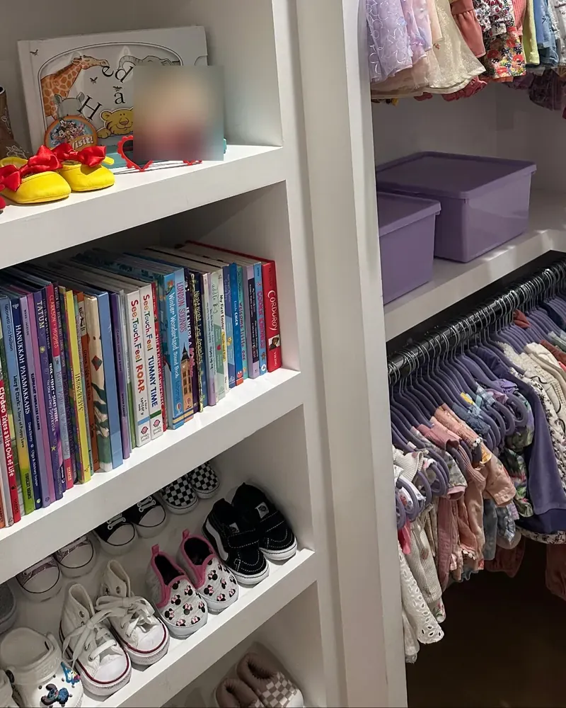 Kids' closet with books, bins, and small shoes on low shelves