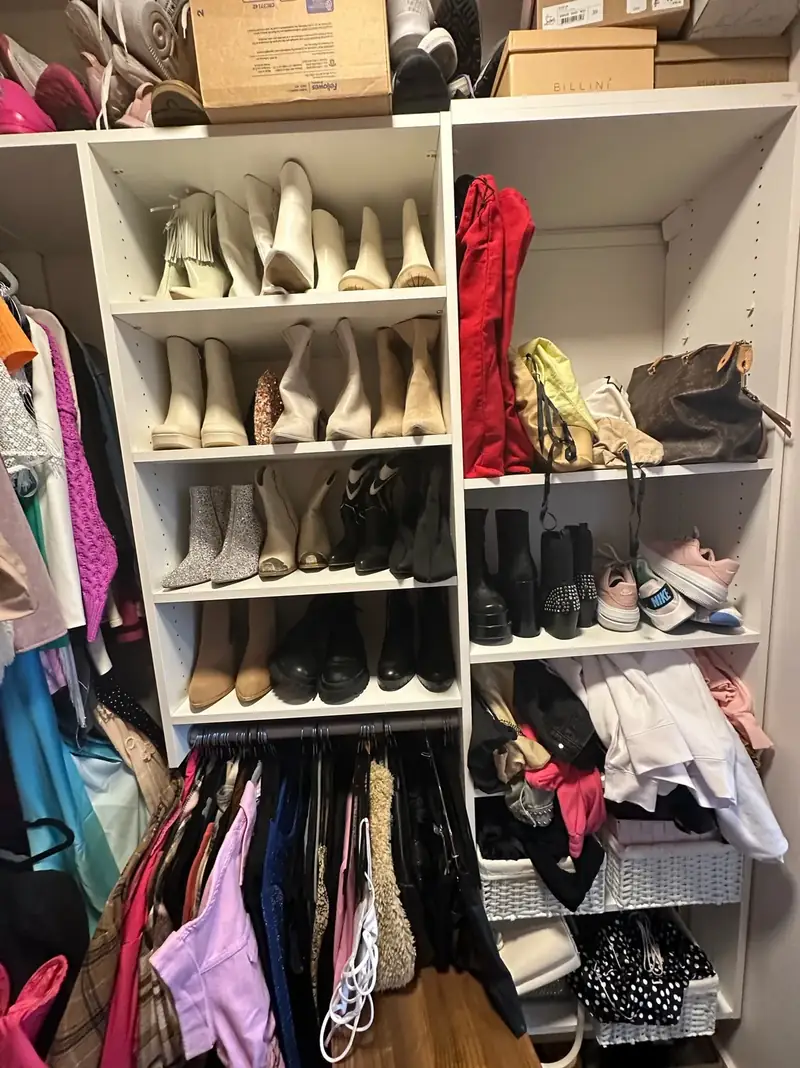Before: Nashville walk-in closet shelves with shoes, boots and bags stacked in mixed rows