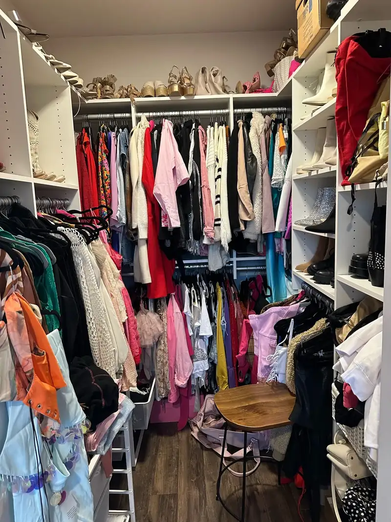 Before: crowded Nashville walk-in closet with packed rods and a stool in the middle of the floor