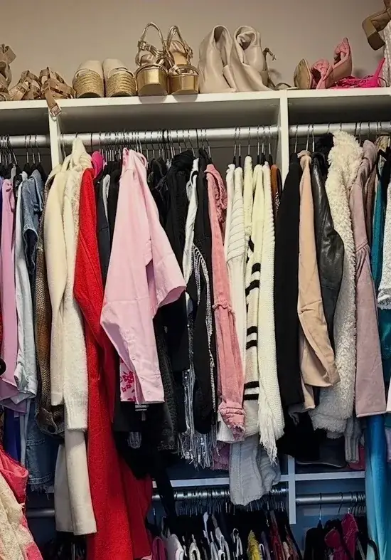 Before: Nashville walk-in closet with a crowded rod of tops and jackets under a shelf of sandals