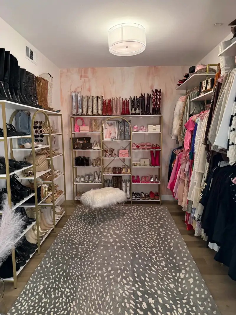 After: Orange County walk-in closet with boots and shoes on gold shelves, clothes hung by color and a spotted rug