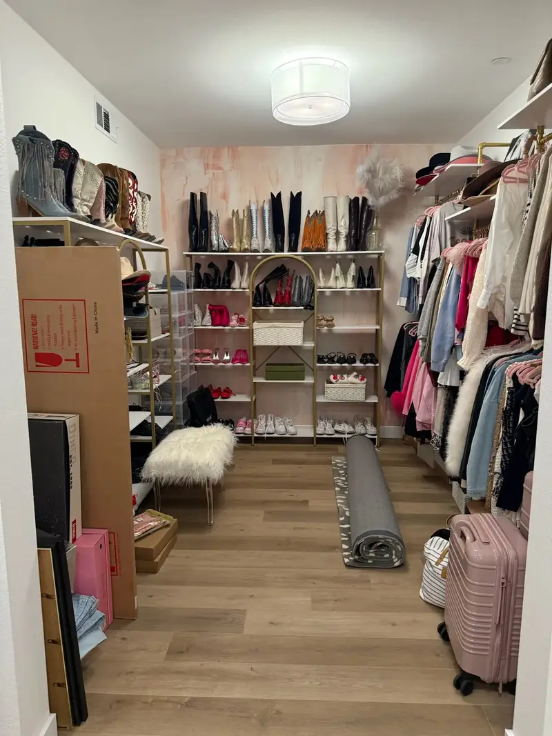 Before: Orange County walk-in closet with a rolled rug, moving boxes and a suitcase on the floor