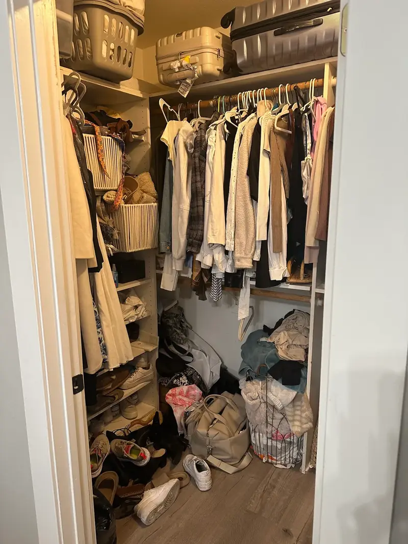Before: crowded Santa Monica closet with shoes and bags piled on the floor under hanging clothes