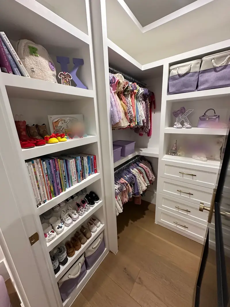 After: West Hollywood girl's walk-in closet with books, little shoes and lavender bins in neat rows on white shelves