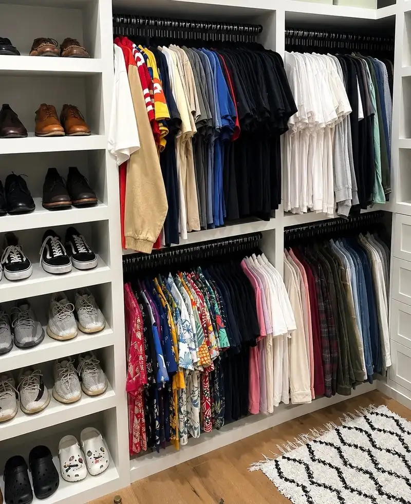 After: West Hollywood walk-in closet with shoes lined up on sage shelves and shirts hung by color